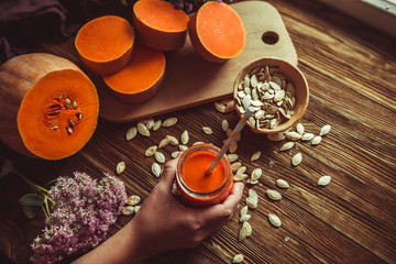 glass of pumpkin juice placed on table near the pumpkins