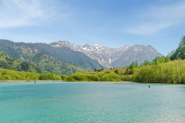 Hotaka mountain range and taisho ike pond in spring at kamikochi national park nagano japan