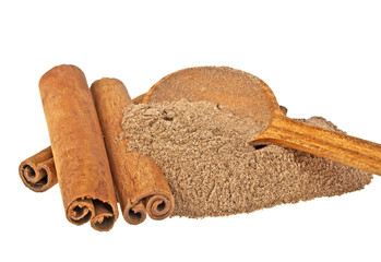 Cinnamon sticks and powder in wooden spoon on a white background