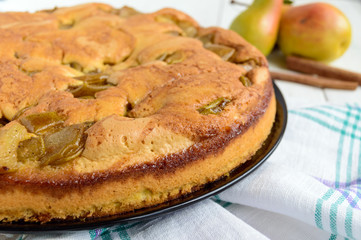 Home baked biscuit flavored pear charlotte cake with cinnamon. On a white wooden background. Close up