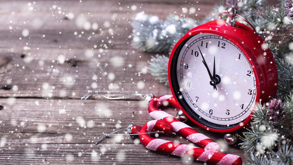 Decorative clock, candy canes and branches fur tree on aged  woo