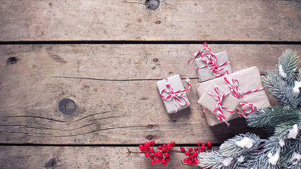 Wrapped christmas presents, fur tree branches, red berries on vi