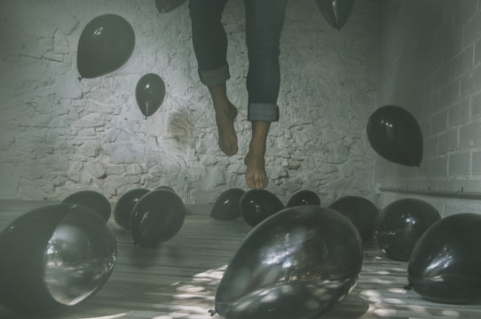 chico levitando entre globos negros
