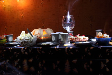 Halloween table illuminated in the dark. Carving pumpkin