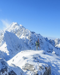 Fototapeta na wymiar Freerider steht am Gipfel und blickt in die imposante Bergwelt