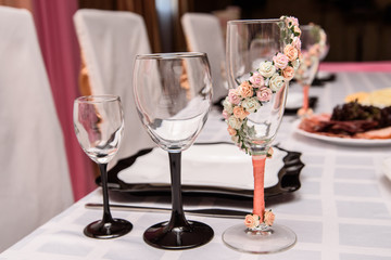 Table setting: black and white plates, glasses and cutlery set on white background.