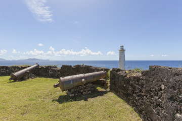 Old cannons and lighthouse at Vieux-Fort