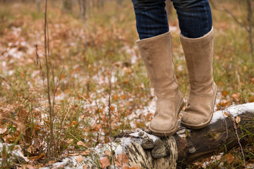 Closeup of woman's legs walking on log in the forest. Girl balancing on fallen old tree.