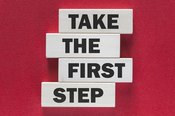 Take the first step. Motivational message written on wooden tiles