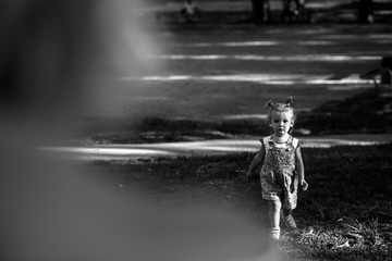 Look from behind mother's shoulder at pretty little girl running