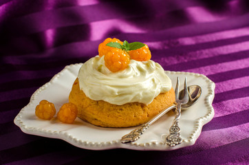 Dessert with cream and berries cloudberries.
