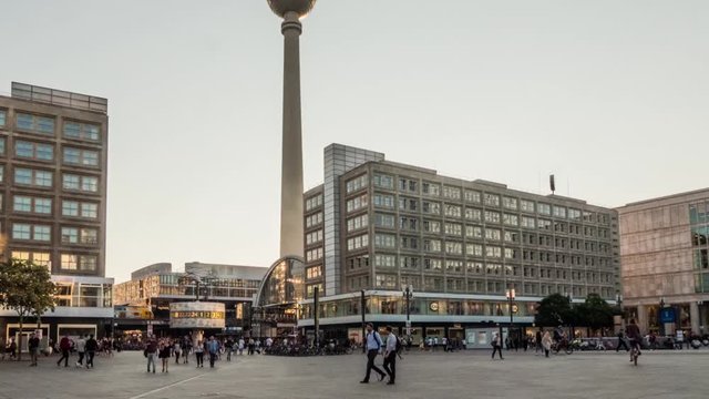 Timelapse: Alexanderplatz is a large public square and transport hub in the central Mitte district of Berlin, Germany, near the Fernsehturm. World clock, people and tram.