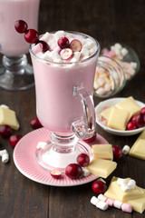 Hot white chocolate with cranberry and marshmallows, wooden table