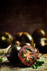 Large black tomato halves on a vintage wooden background, select