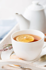 Tray with cup of hot black tea, lemon and honey