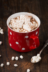 Big red Cup of hot Chocolate drink with Marshmallows and cinnamon on dark wooden background. Winter time. Holiday concept, Selective focus