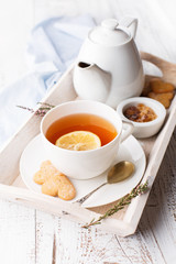 Tray with cup of hot black tea, lemon and honey, selective focus