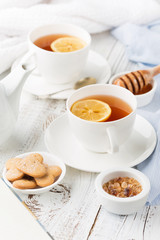 Tray with cup of hot black tea, lemon and honey