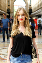 Pretty young woman in black t-shirt stands in the shopping mall