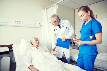 doctor and nurse visiting senior woman at hospital