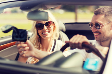 happy couple usin gps navigation system in car