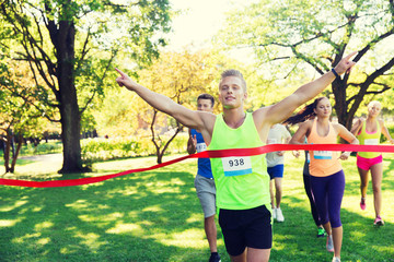 happy young male runner winning on race finish