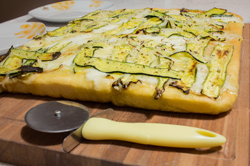 wood cutting board with pizza and knife