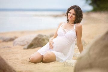 Fototapeta na wymiar Pregnant woman resting on the beach 
