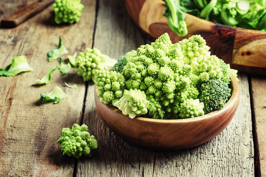 Green romanesco cauliflower in a wooden bowl, vintage wooden bac