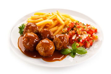 Roasted meatballs, chips and vegetables 