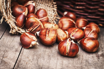 Obraz premium Roasted sweet chestnuts on grey rustic wooden table. Copy space