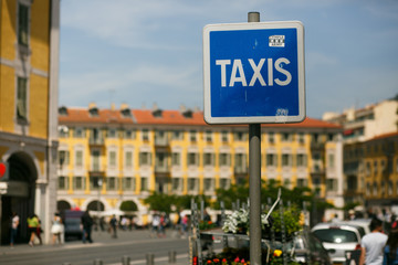 Blue street sign 'Taxis' stands on the Italian street