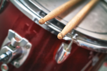 Fototapeta na wymiar Closeup detail of red drums with focus on drumsticks