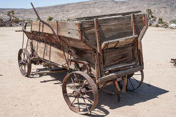 Fototapeta na wymiar Old vintage Wild west wagon in the Mojave desert 