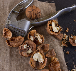 walnuts and nutcracker on table covered with burlap