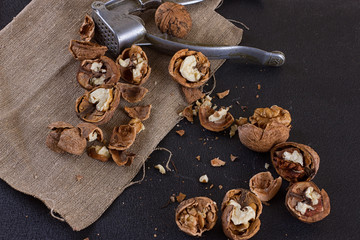 walnuts and nutcracker on table covered with burlap