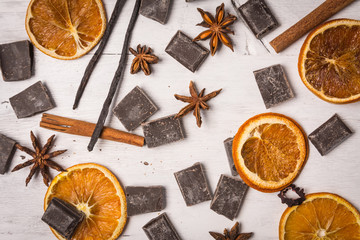 chocolate with cinnamon, orange and vanilla on white wooden table