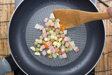 Chef stir fried slice of bacon and vegetable in pan