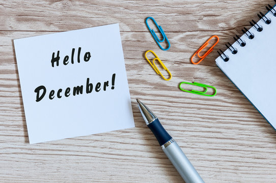 Hello December written on paper at work table. Eve, Christmas and New year time concept