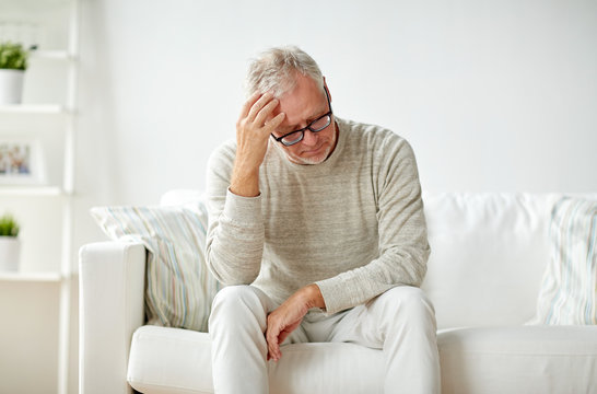 senior man suffering from headache at home