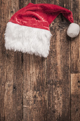 Obraz na płótnie Canvas Santa red hat on wooden background
