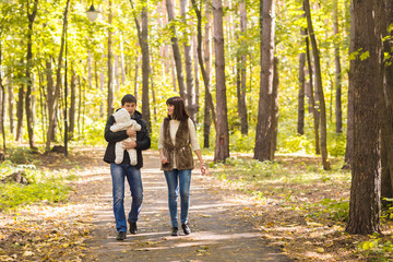Fototapeta premium Young couple with newborn son outdoors in autumn