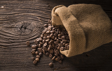 Cup of coffee, bag and scoop on old rusty background