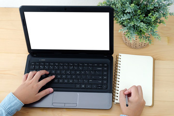 Hand typing laptop with blank screen and blank note paper