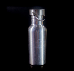 Stainless steel water bottle on a black background.
