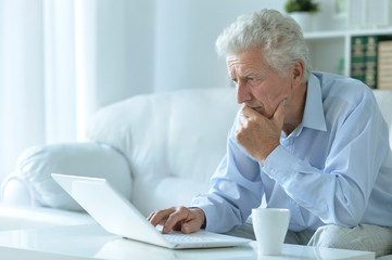 Fototapeta premium senior man at home with laptop