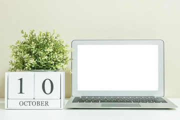White wooden calendar with black 10 october word with white blank space at center of computer...