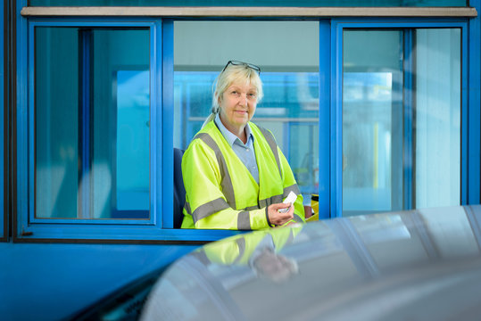 Portrait Of Female Toll Collector At Toll Booth On Bridge