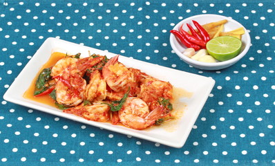 Fried spicy basil with shrimp and side dish as halve green lemon ,red chili and garlic are popular Thai food. 