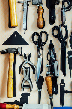 Scissors and tools hanging on wall in arts studio